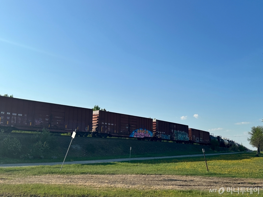 캐나다 퀘벡주 발도흐 소재 합판회사 유니보드 캐나다(Uniboard Canada) 야적장에 쌓인 나무들(위)과 화물수송열차가 루인노랜다역 근처에서 대기 중인 모습. 캐나다에서 채굴·제련되는 주요 배터리 광물은 철도·도로 등 기존 인프라를 통해 운송된다.  /사진=김도현 기자