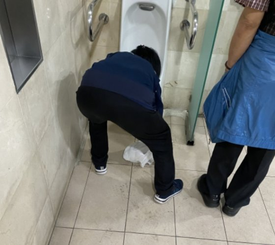 몸을 숙이고, 땀을 흘리며 화장실을 깨끗하게 쓸 수 있게 만들어주는 이들./사진=남형도 기자