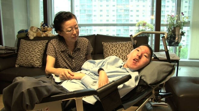 척수성근위축증 2형 환자로 죽을 고비를 넘기고 살아 남은 신형진씨(39)와 그의 어머니. 무려 33년을 기다려 치료제가 나왔고, 9번을 맞으며 기적처럼 나아지는 걸 경험했다. 그러나 건강보험 급여 중단으로 치료제를 더는 맞을 수 없게 됐다./사진=신형진씨 제공