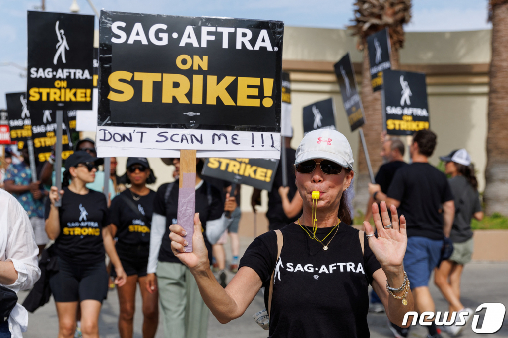 미국 캘리포니아주 LA에 있는 파라마운트 스튜디오 앞에서 배우와 작가들로 이루어진 노조원들이 파업을 알리는 피켓을 들고 행진하고 있다. 2023.07.18  /로이터=뉴스1