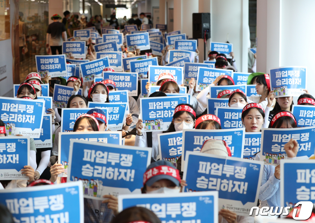 (서울=뉴스1) 신웅수 기자 = 보건의료노조 고대의료원지부 조합원들이 19일 오전 서울 성북구 고려대학교 안암병원에서 열린  파업 7일차 총파업대회에서 구호를 외치고 있다.  이들은 병원 건물이 증축되면서 병상이 증가하고 있지만 직원들은 열악한 노동조건에 허덕이고 있다며 인력 충원과 중증질환에 맞는 숙련된 간호인력 배치 등을 촉구했다. 2023.7.19/뉴스1  Copyright ? 뉴스1. All rights reserved. 무단 전재 및 재배포 금지.