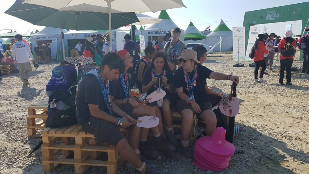 문체부·한국관광공사의 한국관광홍보관에서 '갓'과 '부채' 만들기 등의 K-컬처 체험 프로그램에 참석한 뒤, 파라솔 그늘에 앉아 웃으며 얘기하고 있다/사진= 유동주 기자 