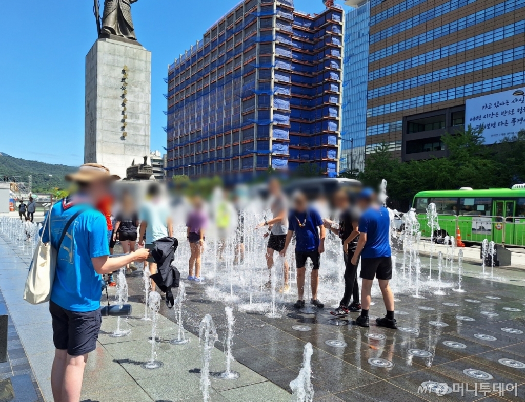 8일 서울 종로구 광화문 광장에서 영국 청소년 잼버리들이 분수에 무더위를 식히고 있다./사진=김지은 기자