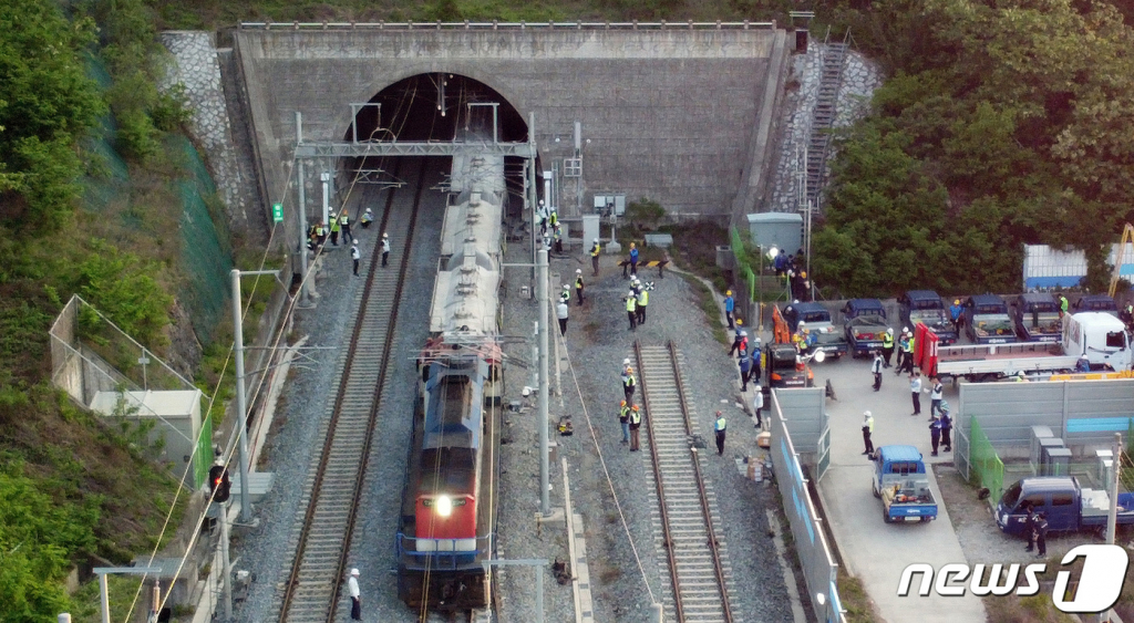 (영천=뉴스1) 공정식 기자 = 10일 오후 경북 영천시 오수동 원제터널에서 코레일 관계자들이 임시 기관차를 투입해 탈선한 대구선 화물열차 일부를 견인하는 등 복구작업을 진행하고 있다.  이날 오전 11시32분쯤 충북 제천에서 경북 칠곡 신동으로 시멘트 등 화물을 싣고 북영천역 인근 원제터널을 통과하던 화물열차 19량 중 5번째 열차가 궤도를 이탈하는 사고가 발생했다. 2023.5.10/뉴스1  Copyright ? 뉴스1. All rights reserved. 무단 전재 및 재배포 금지.