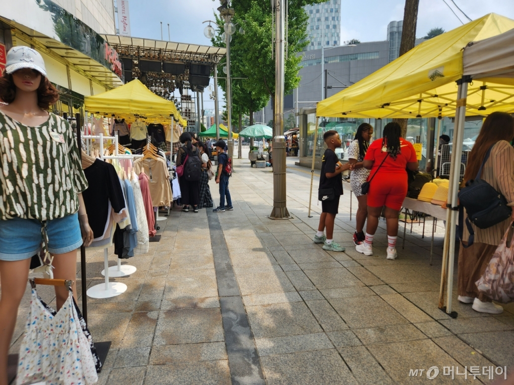 14일 서울 동대문구 한 쇼핑몰 앞에 있는 노상에서 외국인 관광객들이 쇼핑을 하고 있다./사진=최지은 기자