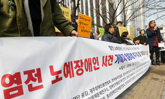 = (서울=뉴스1) 오대일 기자 염전 노예사건 재발 방지를 위한 공동대책위원회 소속 회원들이 25일 오전 서울 서대문구 미근동 경찰청 앞에서 열린 "염전 노예장애인 사건 가해자 엄중 처벌 촉구 및 법적 대책 마련"을 위한 기자회견에서 장애인 인권유린 대책을 촉구하고 있다. 2014.2.25/뉴스1 