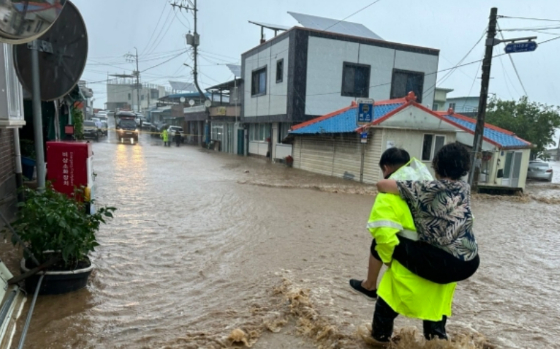 태풍으로 수해 피해가 극심했던 강원도 고성의 광경. 어르신이 업힌 채 구조되고 있다./사진=뉴스1