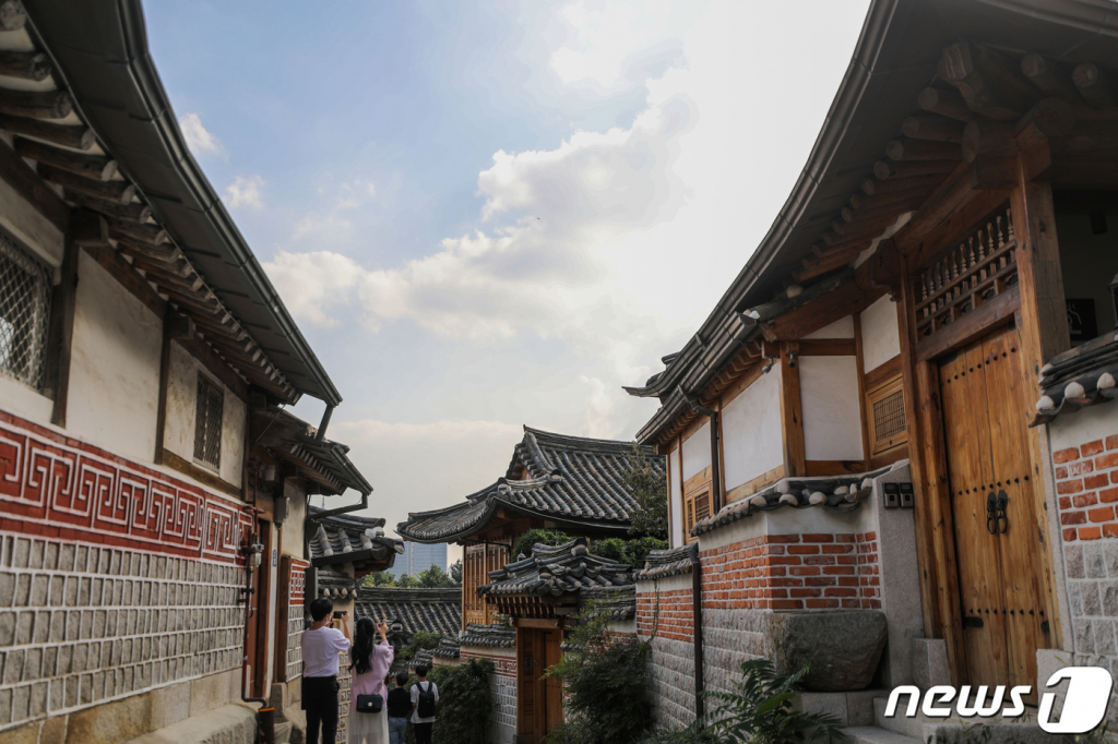 (서울=뉴스1) 허경 기자 = 추석연휴를 이틀 앞둔 28일 서울 종로구 북촌한옥마을을 찾은 시민들이 한옥과 푸른 하늘을 배경으로 기념촬영을 하고 있다. 2020.9.28/뉴스1