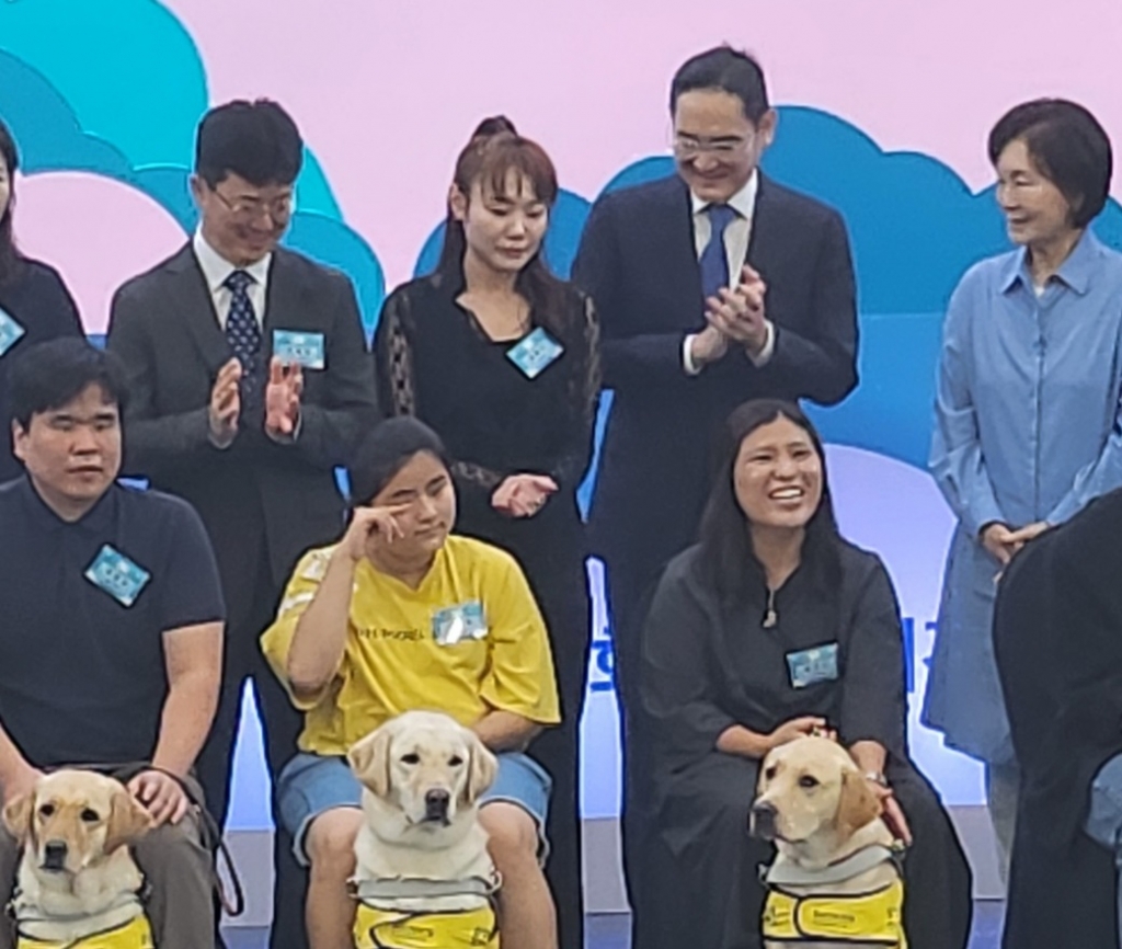 19일 경기도 용인시 삼성화재 안내견학교 기념식에서 안내견을 바라보며 흐뭇해하는 이재용 삼성전자 회장(가장 윗줄 오른쪽 2번째)과 홍라희 전 리움미술관 관장(가장 윗줄 오른쪽 1번째). / 사진 = 오진영 기자