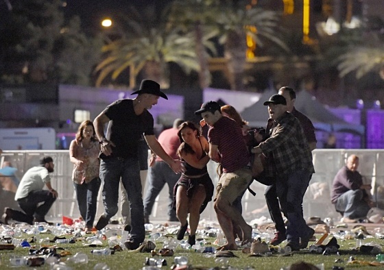 2017년 10월 1일(현지시간) 총기 난사 사건이 발생한 미국 라스베이거스의 야외 공연장에서 관객들이 부상자와 함께 도망치고 있다./사진=AFPBBNews=뉴스1