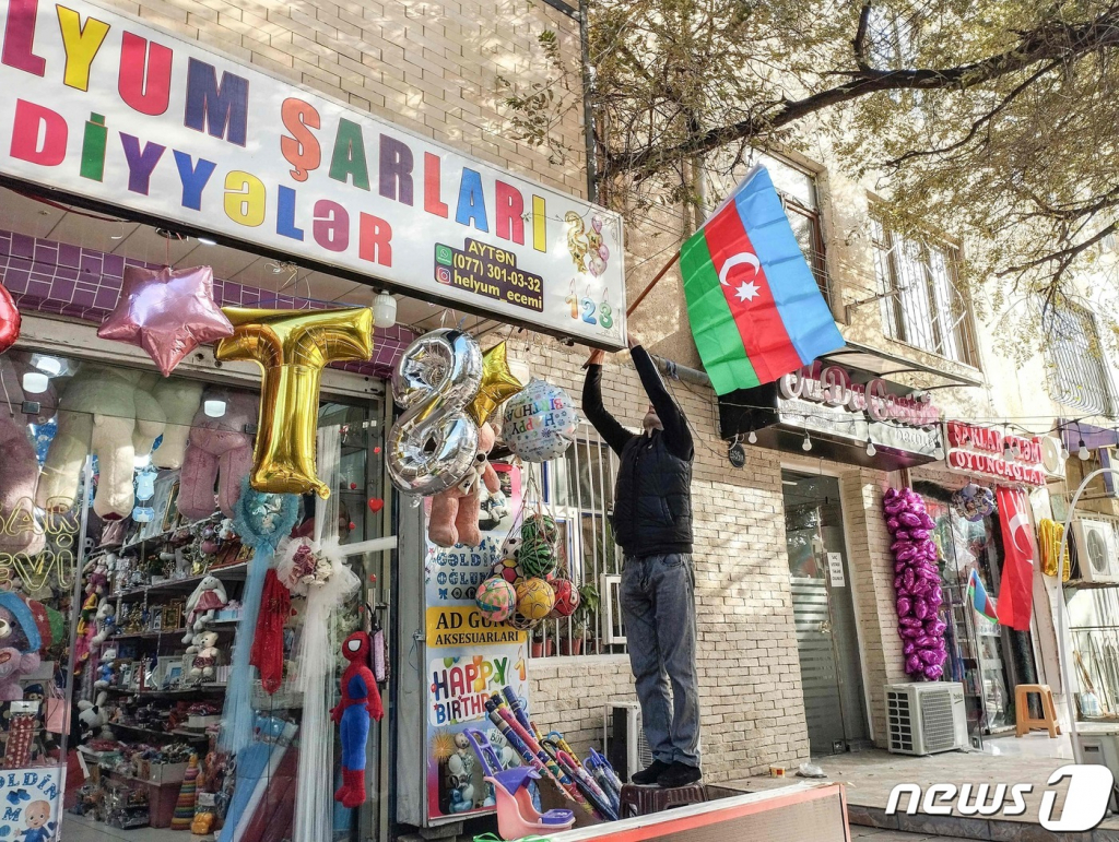 (바쿠 AFP=뉴스1) 김예슬 기자 = 20일(현지시간) 아제르바이잔 수도 바쿠에서 한 주민이 나고르노-카라바흐 지역에서 국가의 공세를 지지하는 뜻으로 가게 앞에 국기를 걸고 있다. 23.09.20  ⓒ AFP=뉴스1  Copyright ? 뉴스1. All rights reserved. 무단 전재 및 재배포,  AI학습 이용 금지.