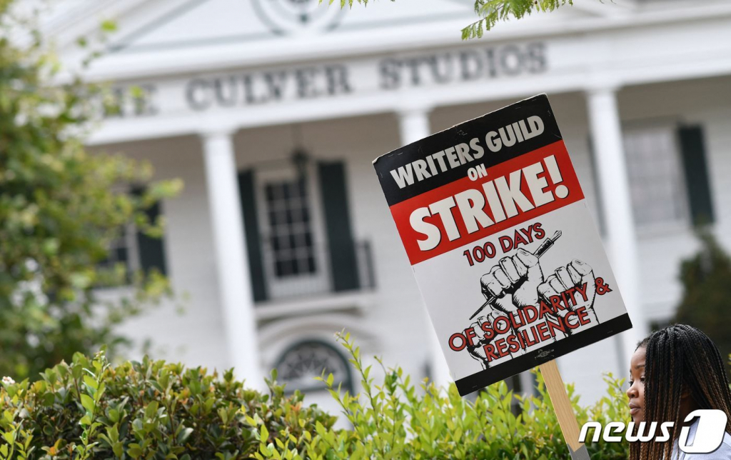 (컬버시티 AFP=뉴스1) 김형준 기자 = 9일(현지시간) 미국 캘리포니아 컬버시티 아마존 스튜디오 앞에서 한 미국작가조합(WGA) 회원이 피켓을 들고 있다. 처우 개선을 요구하는 할리우드 작가들의 파업은 이날로 100일째를 맞았다. 2023.08.10/  ⓒ AFP=뉴스1  Copyright ? 뉴스1. All rights reserved. 무단 전재 및 재배포 금지.