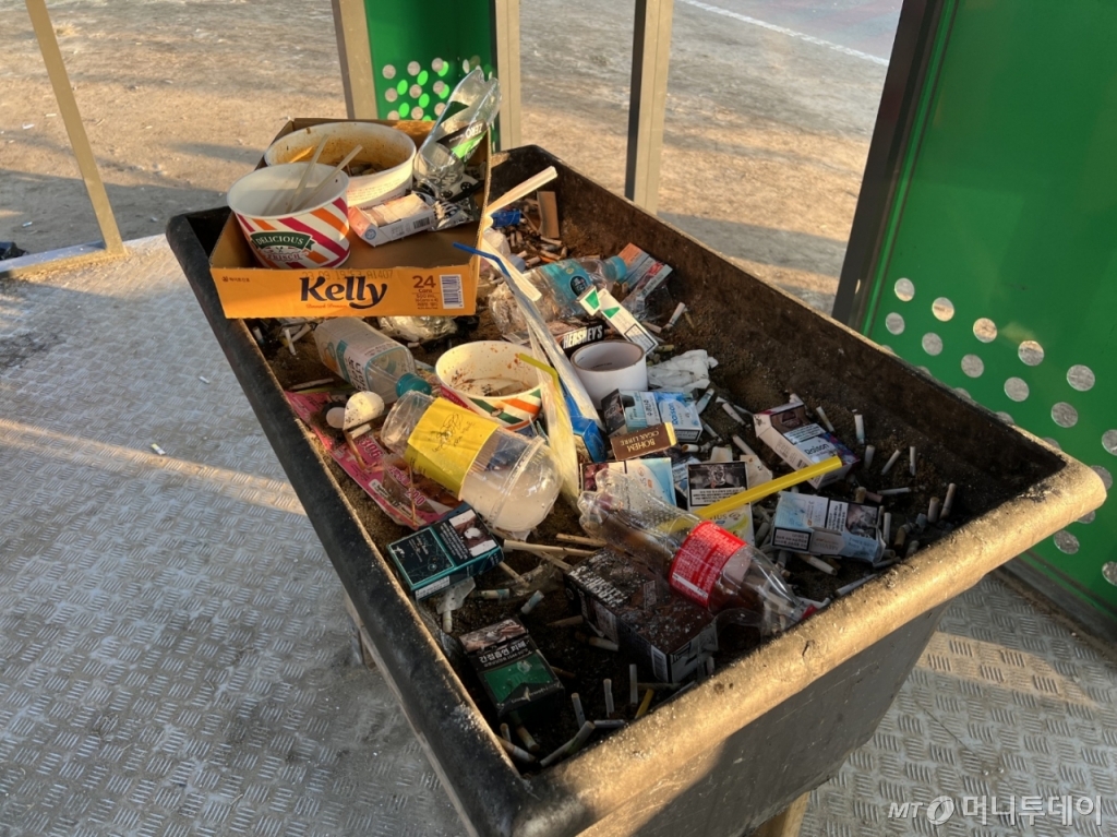 12일 오전 7시30분쯤 서울 영등포구 여의도 한강공원에 있는 흡연부스의 모습. 재떨이 역할을 하기 위해 설치된 곳에 종이 박스와 플라스틱 일회용 컵 등 일반 쓰레기가 쌓여있다./사진=이승주 기자