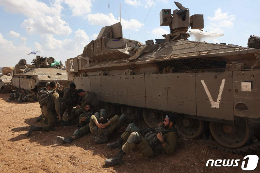 (아슈켈론 AFP=뉴스1) 우동명 기자 = 15일(현지시간) 팔레스타인 무장 정파 하마스의 기습 공격에 대응해 이스라엘 남부 지역인 아슈켈론에서 병사들이 장갑차 아래서 휴식을 하고 있다. 2023.10.16  ⓒ AFP=뉴스1  Copyright ? 뉴스1. All rights reserved. 무단 전재 및 재배포,  AI학습 이용 금지.