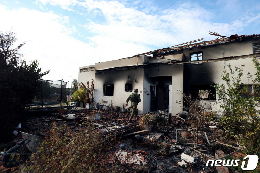 (비에리 로이터=뉴스1) 정지윤 기자 = 17일(현지시간) 이스라엘 남부 비에리 키부츠(집단농장)에서 이스라엘의 군인이 팔레스타인 무장정파 하마스의 공격으로 불타고 남은 집 안으로 들어가고 있다. 2023.10.18  ⓒ 로이터=뉴스1  Copyright ? 뉴스1. All rights reserved. 무단 전재 및 재배포,  AI학습 이용 금지.