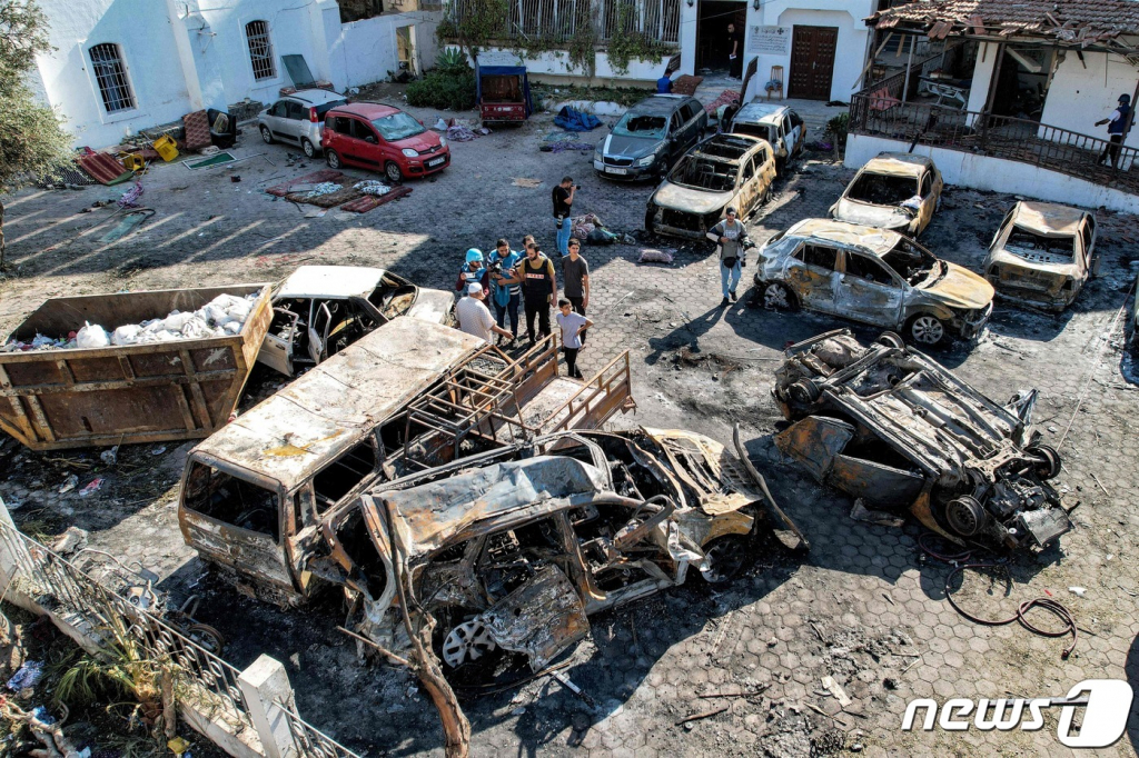 18일(현지시간) 팔레스타인 무장정파 하마스가 통치하고 있는 가자 지구의 병원 폭발 참사 현장의 파괴된 건물 앞에 불에 탄 차량들이 보인다. 2023.10.18  ⓒ AFP=뉴스1  Copyright ? 뉴스1. All rights reserved. 무단 전재 및 재배포,  AI학습 이용 금지.