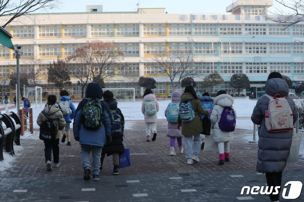 (서울=뉴스1) 박세연 기자 = 27일 서울시내 한 초등학교에서 마스크를 쓴 학생들이 등교를 하고 있다.   교육부가 30일부터 학교 실내 마스크 착용을 의무에서 자율 착용으로 조정하기로 했다. 교육부는 이날 변경된 ‘실내 마스크 착용 방역 지침’ 시행에 따른 각급 학교, 학원에서 적용할 세부기준을 발표하고 이 같이 밝혔다. 다만 학교 통학이나 학원 이용, 행사·체험 활동 등과 관련된 단체 버스 등의 차량을 이용할 때는 반드시 마스크를 착용해야 한다. 2023.1.27/뉴스1  Copyright © 뉴스1. All rights reserved. 무단 전재 및 재배포 금지.