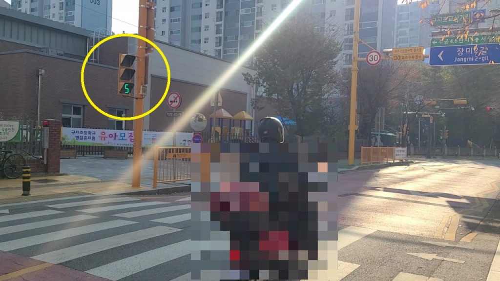 15일 오전 11시쯤 구지초교 인근에서 한 오토바이가 신호를 무시하고 스쿨존 앞을 그대로 지나고 있다./영상=천현정 기자