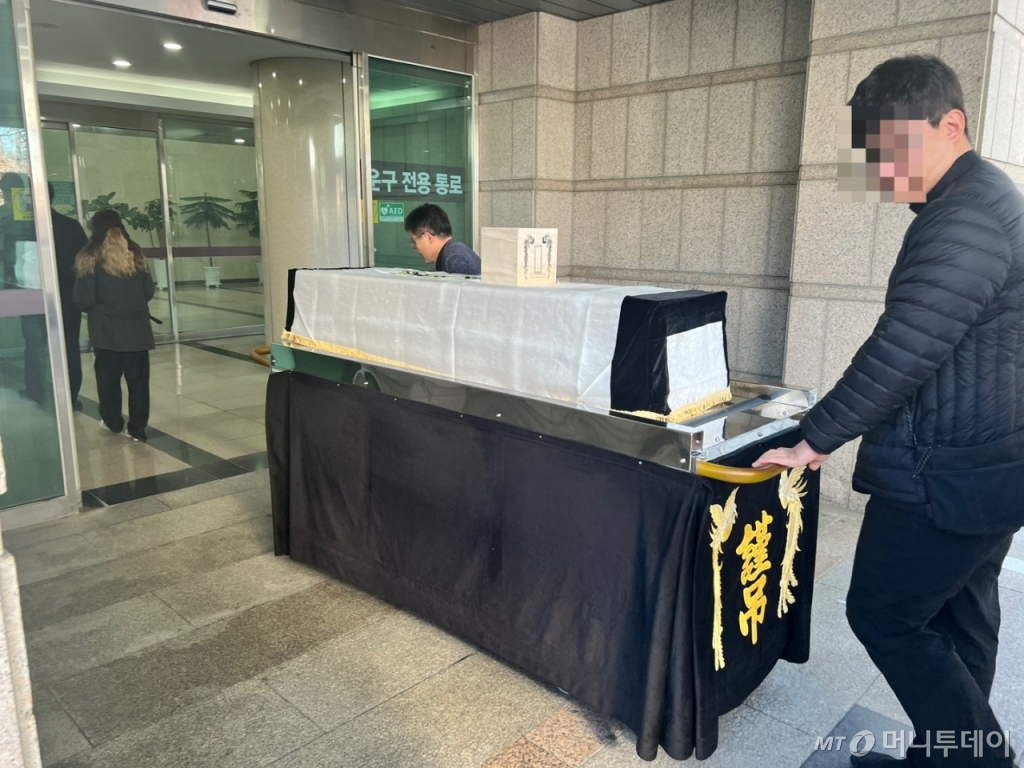 21일 오전 10시39분 경기도 고양시 서울시립승화원에서 이민수 천주교 서울대교구 빈민사목위원회 신부가 무연고자의 관을 1층 화장소로 운구하고 있다./사진=민수정 기자