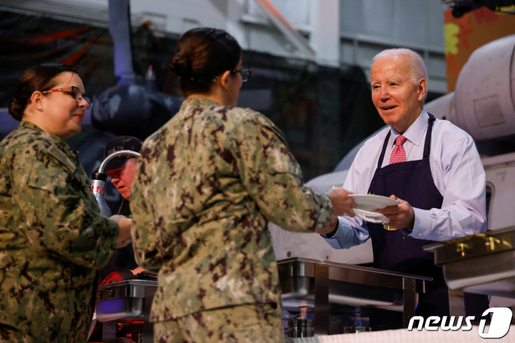 (노퍽 로이터=뉴스1) 정지윤 기자 = 조 바이든 미국 대통령이 19일(현지시간) 미국 버지니아주 노퍽의 해군기지에서 추수감사절 연휴를 앞두고 열린 '프렌즈기빙' 행사에서 군 장병과 그 가족들에게 음식을 배부하고 있다. 2023.11.20  ⓒ 로이터=뉴스1  Copyright © 뉴스1. All rights reserved. 무단 전재 및 재배포,  AI학습 이용 금지.