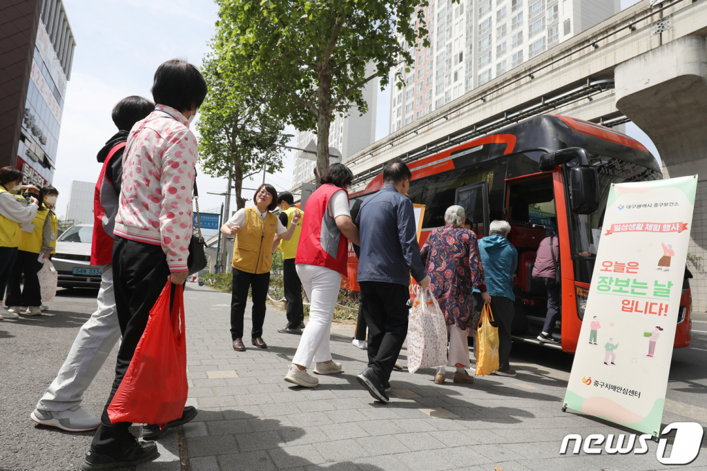 (대구=뉴스1) 공정식 기자 = 24일 오전 대구 중구 남산동의 한 마트에서 열린 경증치매환자 일상생활 체험 '오늘은 장보는 날' 행사에 참여한 어르신들이 자원봉사자의 도움을 받아 상품을 구매한 뒤 장바구니를 들고 버스로 향하고 있다.  중구치매안심센터가 경증치매환자의 독립성 향상을 위해 마련한 장보기 체험은 경증치매환자와 치매전문봉사자인 청라지기가 1대 1로 짝을 이뤄 실제로 장을 보고 구매하는 과정으로 진행됐다. 2023.5.24/뉴스1  Copyright © 뉴스1. All rights reserved. 무단 전재 및 재배포 금지.