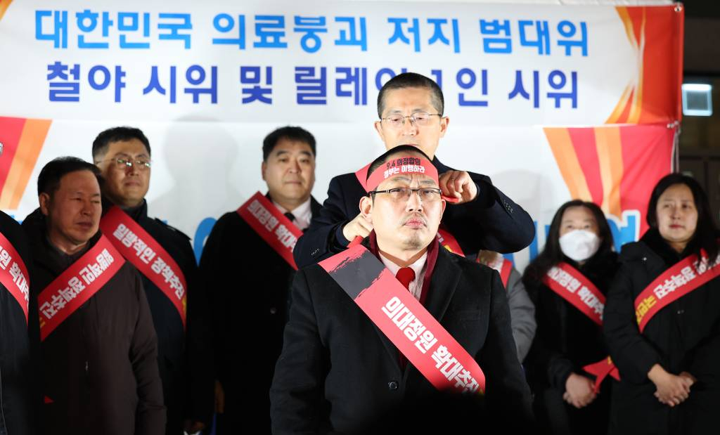 [서울=뉴시스] 최진석 기자 = 이필수 대한의사협회 회장이 6일 서울 용산 대한의사협회 앞 천막농성장에서 열린 대한민국 의료붕괴 저지 범대위 철야 시위 및 릴레이 1인 시위 관련 기자회견에서 삭발식을 마친 최대집 대한민국의사협회 범의료계 대책특별위원회 위원장에게 9.4의정합의 촉구 머리띠를 둘러주고 있다. 2023.12.06.