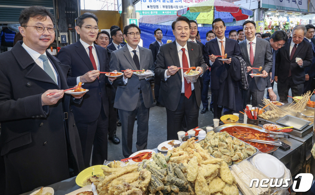 (부산=뉴스1) 부산사진공동취재단 = 윤석열 대통령이 6일 부산 중구 깡통시장을 방문해 박형준 부산시장과 이재용 삼성전자 회장, 구광모 LG그룹 회장, 조현준 효성그룹 회장, 김동관 한화그룹 부회장, 최재원 SK수석부회장 등 기업총수들과 함께 떡볶이, 튀김, 빈대떡을 맛보고 있다. 2023.12.6/뉴스1 Copyright © 뉴스1. All rights reserved. 무단 전재 및 재배포, AI학습 이용 금지.