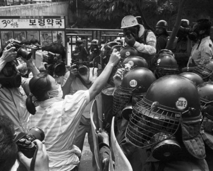 1987년 6월항쟁 당시 서울 종로거리에서 한 여성 시위 참가자가 전경에게 꽃을 건네고 있다. /사진제공=민주화운동기념사업회 