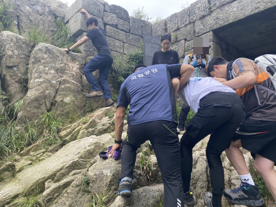 부상자를 헬기 포인트까지 옮기기 위해 함께 애쓰던 이들./사진=박준흠 소방장 제공