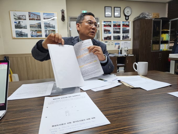 ▲김인국 위원장이 전곡산단 분양시 기업인들에게 제시됐던 계약 서류들을 보여주고 있다. /사진=머니투데이 임윤희 기자 