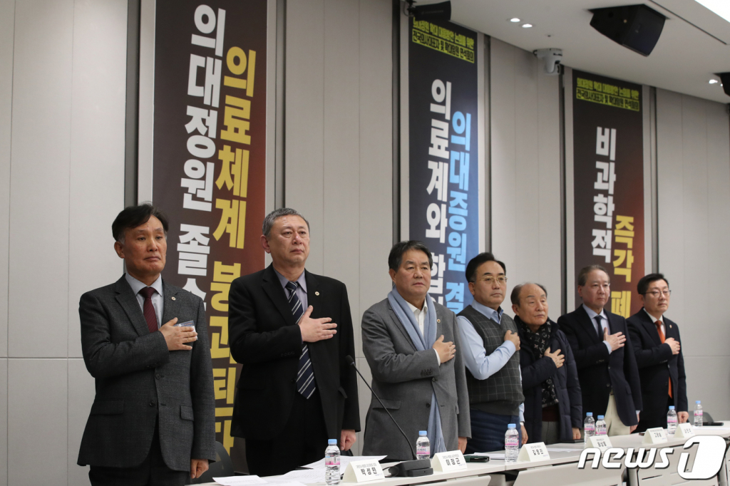 (서울=뉴스1) 이광호 기자 = 박성민 의협 대의원회 의장 등이 7일 오후 서울 용사구 대한의사협회에서 열린 2024년도 긴급 임시대의원총회에서 참석자들과 국기에 경례를 하고 있다.  이날 의협은 임시대의원총회에서 의대 증원 저지를 위한 비상대책위원회 설치 안건 등에 대해 논의한다. 2024.2.7/뉴스1  Copyright © 뉴스1. All rights reserved. 무단 전재 및 재배포,  AI학습 이용 금지.