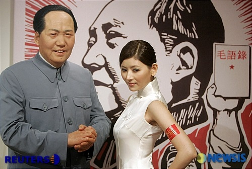 홍콩의 투소 밀랍인형관에 설치된 덩샤오핑 전 중국 주석의 밀랍인형 옆에서 한 모델이 포즈를 취하고 있다. /AP=뉴시스