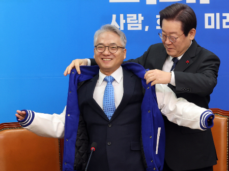 이재명 더불어민주당 대표가 지난해 12월 27일 오전 서울 여의도 국회에서 열린 민주당 4·5호 인재영입식에서 인재영입 4호 박선원 전 국가정보원 제1차장에게 당 점퍼를 입혀주고 있다. / 사진=뉴스1