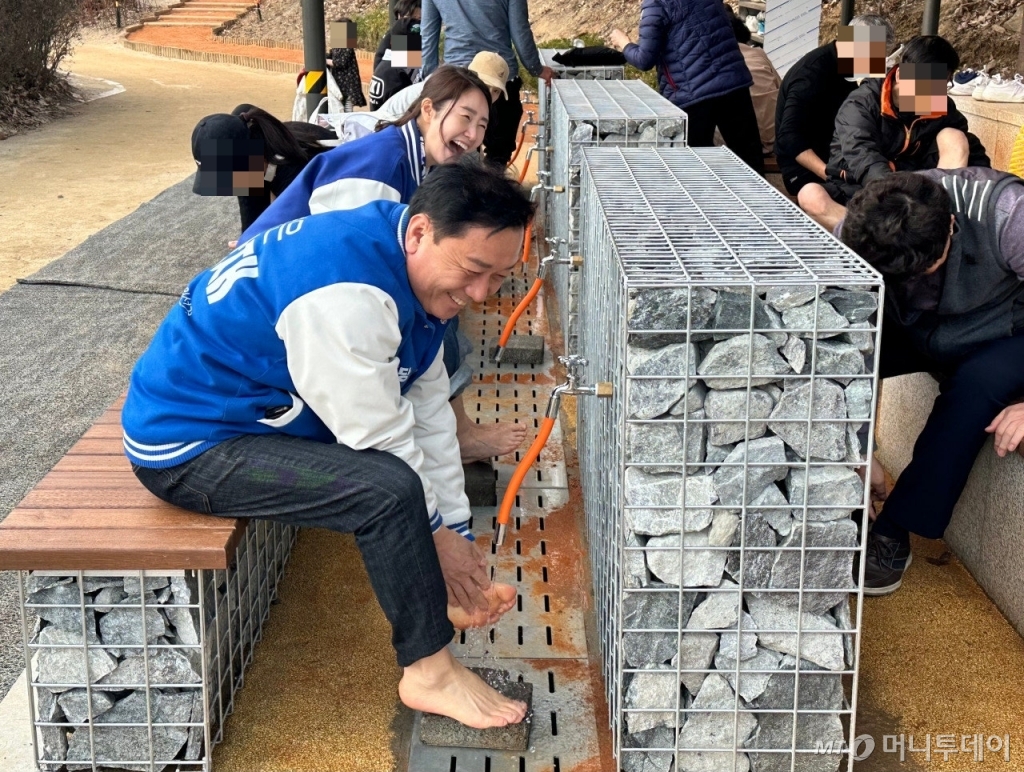 더불어민주당 경기 성남분당갑 이광재 후보가 황톳길 걷기 체험을 마치고 발을 씻으면서 주민들과 대화하는 모습 /사진=김도현 기자