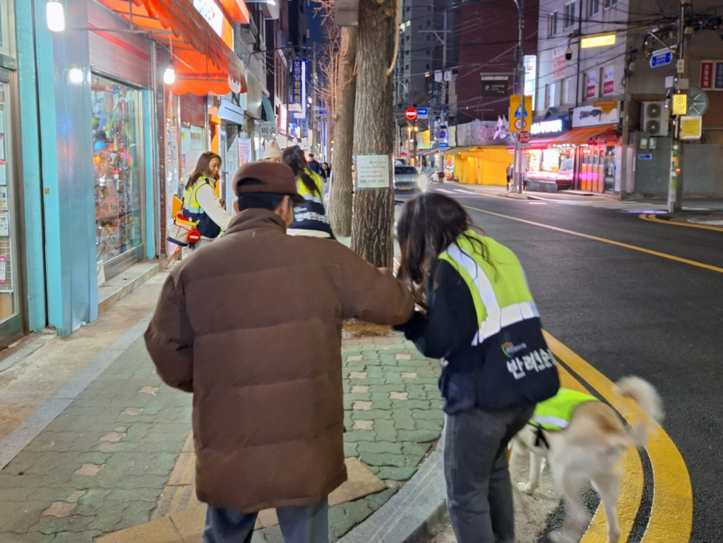 지난 21일 한 시민이 반려견 순찰대원을 보고 "수고가 많다"며 사탕을 건네는 모습. /사진=김지은 기자