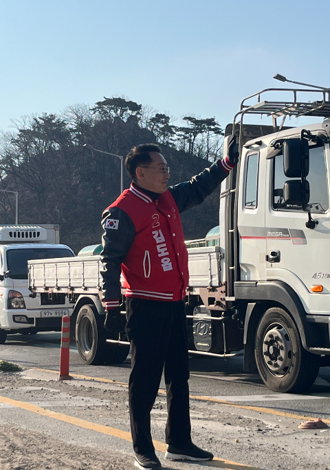 김도읍 국민의힘 부산 북·강서을 의원이 강서구 한 교차로에서 신호대기 중인 차들에 인사를 하고 있다. /사진=한정수 기자