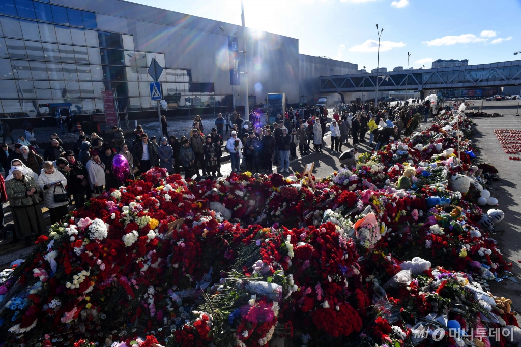 지난 25일(현지시간) 모스크바 외곽 크라스노고르스크에 있는 크로커스 시티홀 공연장 테러 현장에서 주민들이 헌화를 하고 있다. /로이터=뉴스1