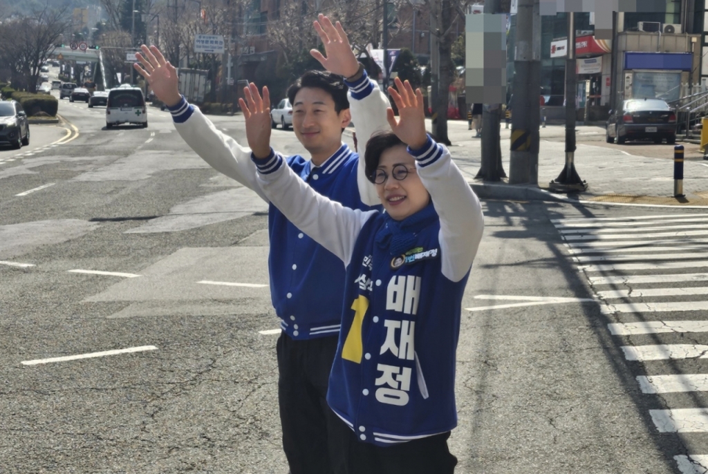 배재정 더불어민주당 후보와 서태경 전 청와대 행정관이 지난 27일 부산 사상구에서 도로를 향해 손을 흔들고 있다./사진=이승주 기자