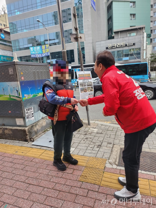 정연욱 국민의힘 부산 수영구 국회의원 후보가 27일 수영구 주민에게 명함을 주며 인사하고 있다./사진=안채원 기자