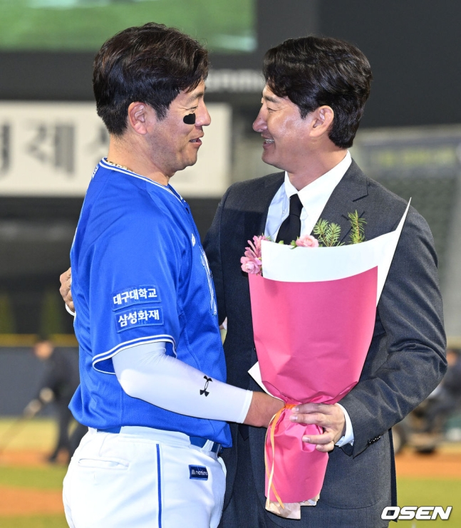 KBO 리그 최초 2238경기 출장 기록을 쓴 강민호를 향해 종전 기록 보유자인 박용택 야구 해설위원이 28일 잠실구장을 찾아 5회 클리닝 타임 때 축하 인사를 전하고 있다.