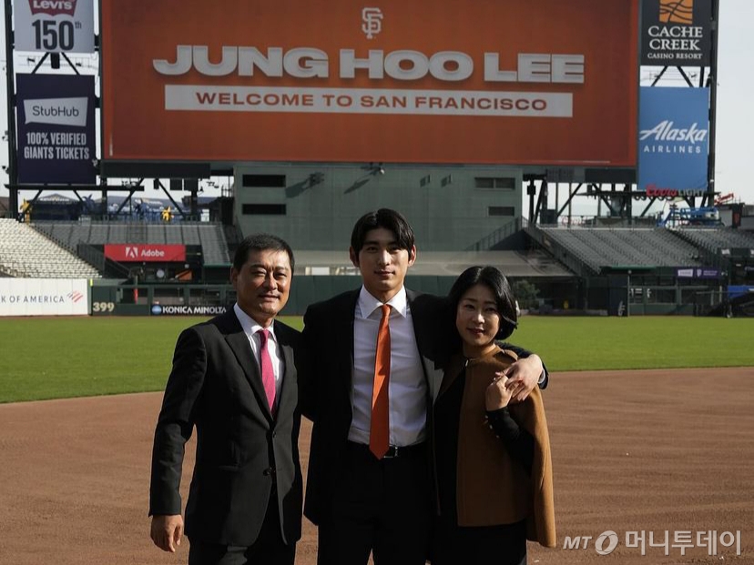 미국 메이저리그(MLB) 샌프란시스코 자이언츠에 입단한 이정후가 지난해 12월 캘리포니아주 오라클 파크에서 열린 입단식에서 아버지 이종범 전 LG트윈스 코치, 어머니 정현희씨와 함께 기념촬영을 하는 모습. /사진=뉴스1 