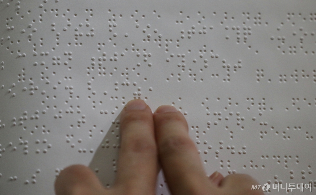 (수원=뉴스1) 김영운 기자 = '점자의 날'을 이틀 앞둔 2일 오후 경기 수원시 영통구 사랑샘도서관에서 한 시각장애인이 점자책을 읽고 있다.   ‘점자의 날’은 시각장애인의 세종대왕이라 불리는 송암 박두성 선생이 시각장애인을 위한 한글 점자를 만들어 반포한 1926년 11월 4일을 기념하는 날이다. 2023.11.2/뉴스1  Copyright © 뉴스1. All rights reserved. 무단 전재 및 재배포,  AI학습 이용 금지. /사진=(수원=뉴스1) 김영운 기자