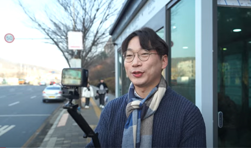 모 후보가 인천 서구 검단신도시의 한 버스정류장 앞에서 셀카봉을 들고 자신의 유튜브 채널 속 코너인 '이번 정류장은 모경종입니다'를 촬영하고 있다. /사진='모두 모경종' 유튜브 영상 화면 갈무리 