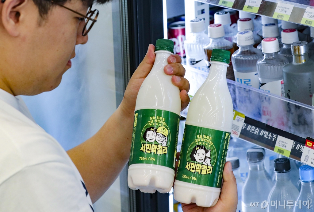 [서울=뉴시스] 김근수 기자 = 20일 오전 서울 강남구 CU편의점 매장을 찾은 시민이 서민맥주를 고르고 있다. 편의점 CU는 지난 5월 물가 안정에 기여하기 위해 초가성비로 출시한 서민막걸리의 한 병당 가격을 1000원으로 책정했다. /사진제공=뉴시스