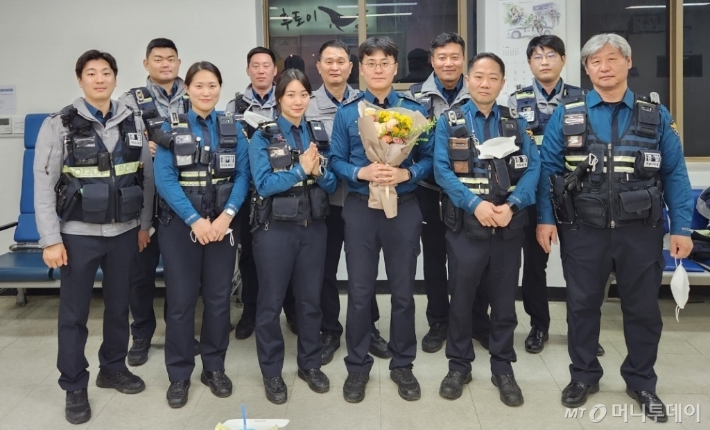 이호균 경장이 지난해 승진을 축하해주는 동료들과 촬영한 사진. 이 경장은 가운데 꽃다발을 들고 서 있다. /사진=이호균 경장 제공