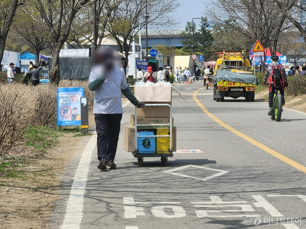 불법 노점상 행렬은 200m가 넘도록 이어졌다. 이 구간에 설치된 불법 노점상 수를 세보니 21곳이었다. 불법 노점상 상인들이 카트에 식용유, 박스 등 물건을 실어 옮기며 자전거 전용 도로 대부분을 차지하는 경우도 있었다./사진=최지은 기자 