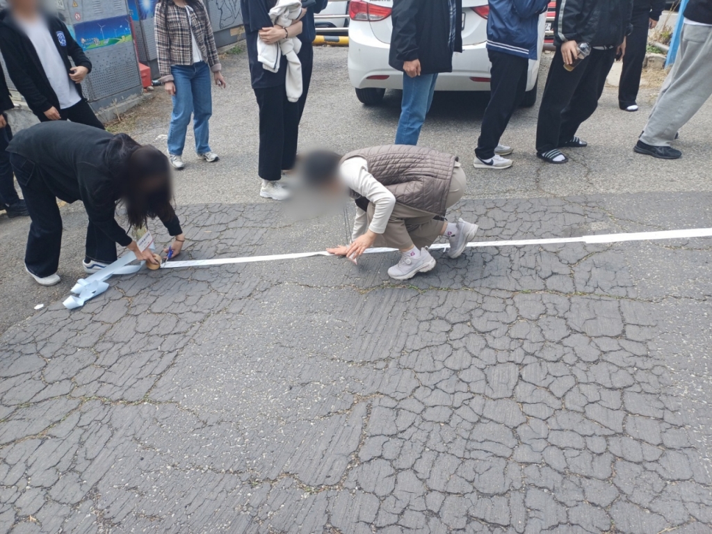 5일 오후 12시40분쯤 유권자가 몰린 탓에 줄이 투표소 울타리를 넘어 비탈길 중간까지 생기자 선거사무원들이 바닥에 줄 구분선을 만들고 있다/사진=오석진 기자 