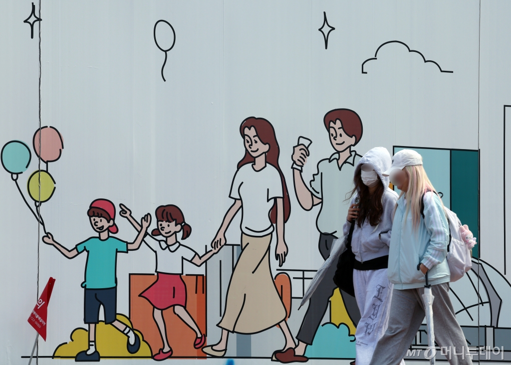 지난 2월 출생아 수가 지난해 같은 달보다 3.3% 줄어들며 처음으로 1만 명대로 내려앉은 가운데 24일 오후 서울 도심의 공사장 가림막에 그려진 행복한 가족 그림 앞으로 시민이 지나고 있다. 2024.4.24/사진=뉴스1 Copyright © 뉴스1.