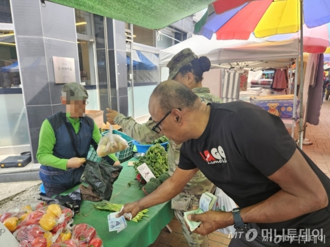 지난 28일 경기 평택시 안정리 캠프 험프리스 인근 오일장에서 한 미군 가족이 양파를 사고 있다. /사진=정세진 기자 