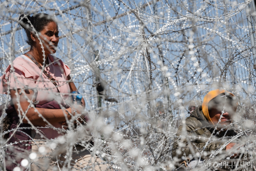 (엘 파소 로이터=뉴스1) 정지윤 기자 = 22일(현지시간) 멕시코에서 미국 텍사스주 엘파소로 건너가려는 한 이민자 여성이 국경에서 텍사스 법 집행관과 대화하고 있다. 2024.03.22  ⓒ 로이터=뉴스1  Copyright © 뉴스1. All rights reserved. 무단 전재 및 재배포,  AI학습 이용 금지. /사진=(엘 파소 로이터=뉴스1) 정지윤 기자